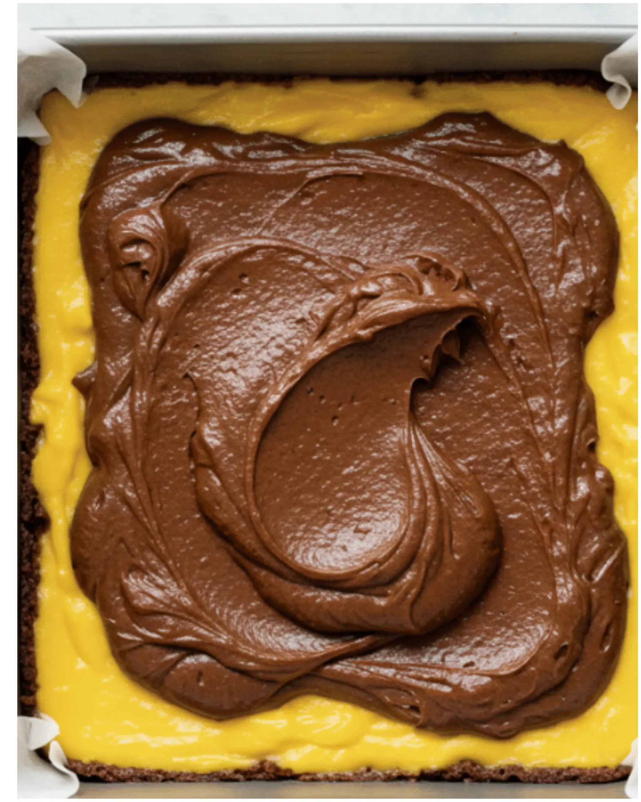 Swirling mango puree and cheesecake into brownie batter