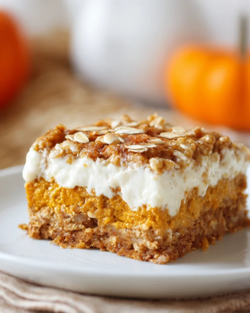 High Protein Cottage Cheese Pumpkin Bake – Healthy Fall Dessert 2 Close-up of a slice of high protein cottage cheese pumpkin bake on a white plate, layered with creamy cottage cheese, spiced pumpkin, and oat crumble topping.