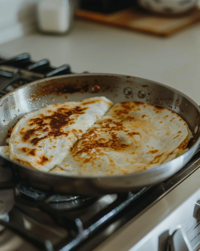 Breakfast Quesadillas Recipe: 5 Easy Steps to a Crispy, Cheesy Morning Start 5 Breakfast quesadilla cooking in a skillet with golden edges and melted cheese in a bright modern kitchen