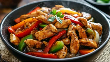 Black pepper chicken served hot with bell peppers and savory sauce