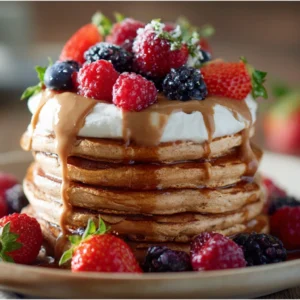 Protein pancakes with yogurt and berries on breakfast table