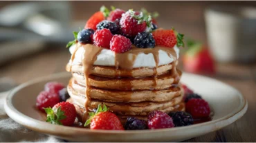 Protein pancakes with yogurt and berries on breakfast table