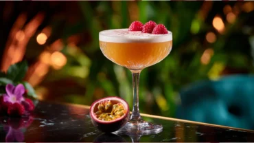 Raspberry Passionfruit Tequila Sour with foam and tropical garnish