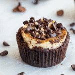 Loaded brownie cheesecake cup with cream cheese swirl on rustic wood