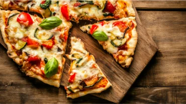 Cottage cheese crust pizza with fresh toppings on a rustic board