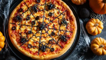 Halloween Spider Web Pizza with olive spiders on a platter