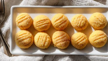 A cozy plate of sweet orange cream cheese mints in warm sunlight.