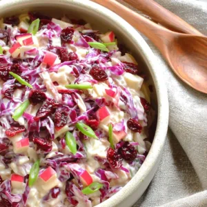 Cranberry apple coleslaw in ceramic bowl with autumn styling