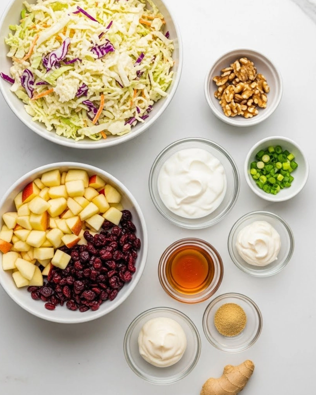 Coleslaw ingredients laid out with apples, cranberries, and walnuts
