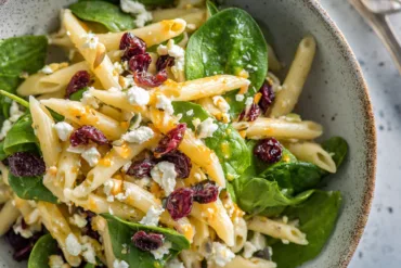 Feta & Cranberry Penne Salad in rustic bowl with orange vinaigrette