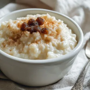 traditional rice pudding in a ceramic bowl with cinnamon on a wood table
