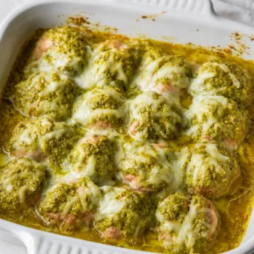 Pesto Baked Turkey Meatballs served with a side of fresh vegetables.