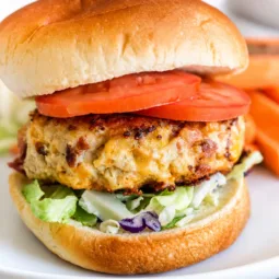 Cheddar Ranch Chicken Burger Patties served on a plate with fresh toppings