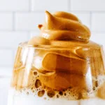 Dalgona coffee whipped with instant coffee, sugar, and hot water, served over milk.