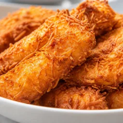 Crispy Pineapple Fritters coated in a light batter, served warm for a sweet treat.