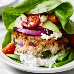 Healthy Greek Chicken Burgers with feta and fresh herbs on a plate