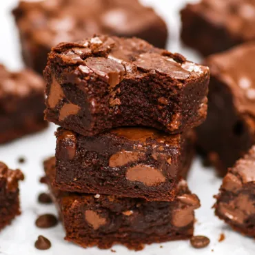 Delicious Coffee Brownies topped with creamy Silky Mocha Frosting on a white plate.